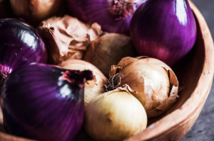 macro image of a bowl of deep purple and yellow onions featured in the nutritional value of onions.